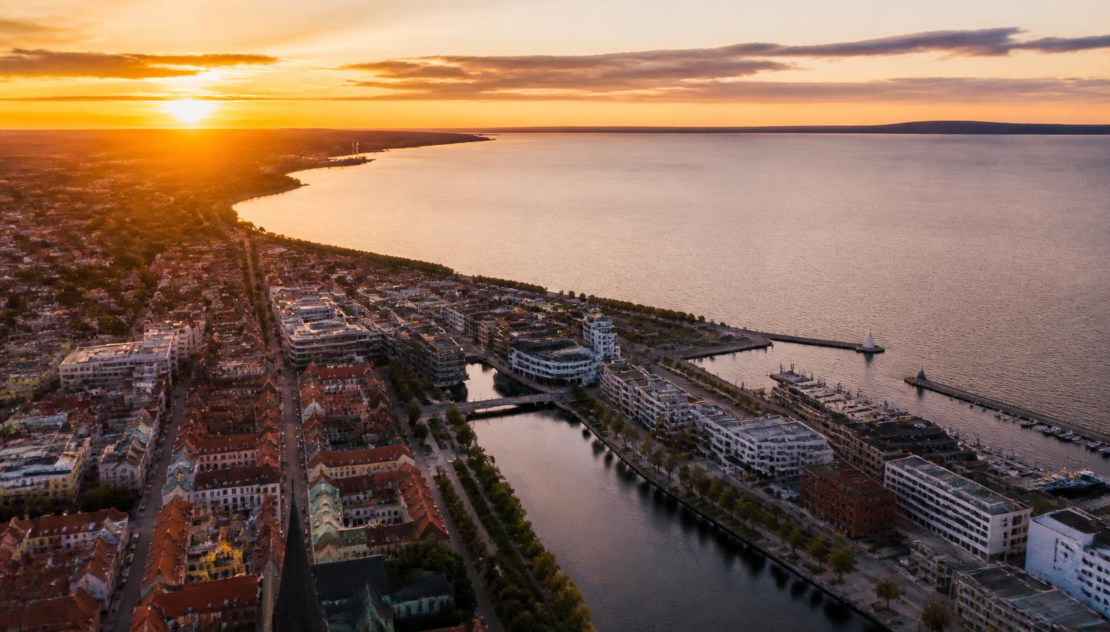 Flygbild över Jönköping vid Vätterns södra strand i solnedgången — hamnen, Munksjön och Östra kajen